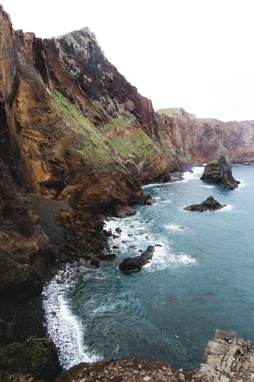 Free Breathtaking view of towering coastal cliffs and crashing waves. Ideal for travel and nature themes. Stock Photo
