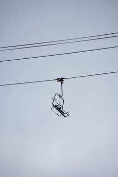 A solitary ski lift chair suspended in air, creating a sense of tranquility and solitude.