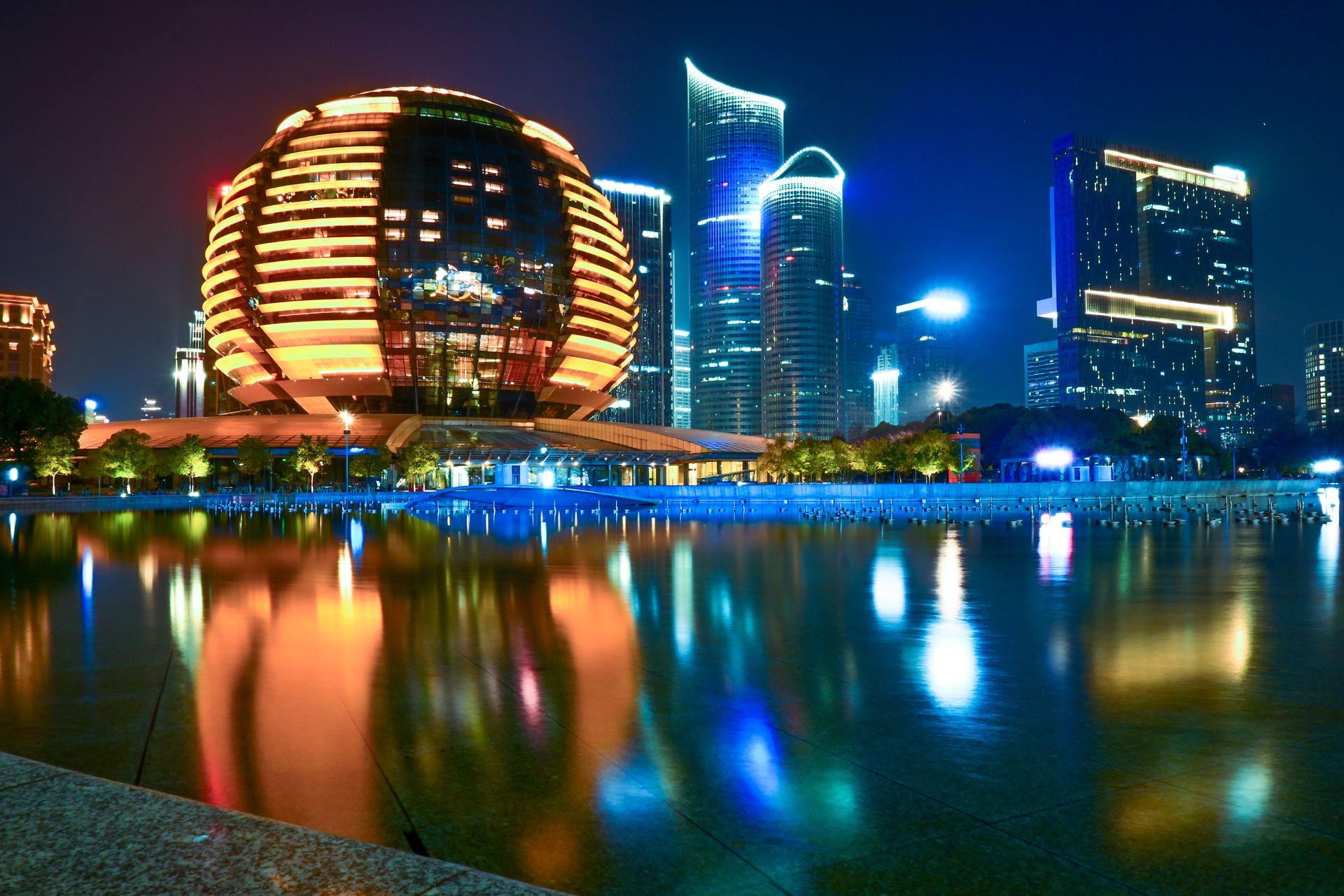 Stunning reflection of Hangzhou's illuminated skyline featuring modern architecture during the night.