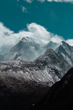 Breathtaking view of snow-covered mountains with dramatic clouds, creating a majestic landscape.
