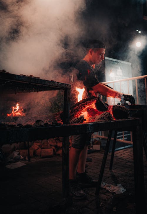 A man is cooking food on a grill