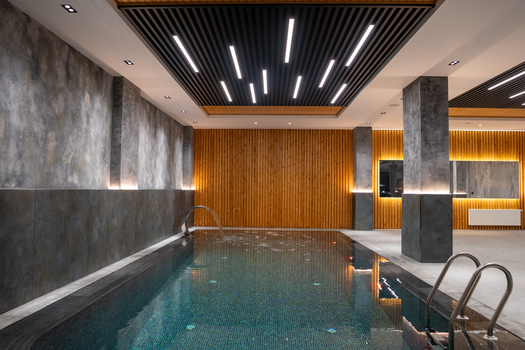 Elegant indoor swimming pool area with modern lighting and wooden accents.