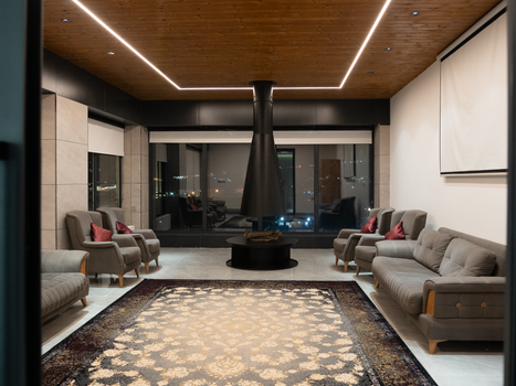 Spacious living room with contemporary design, featuring a unique suspended fireplace and elegant furniture.