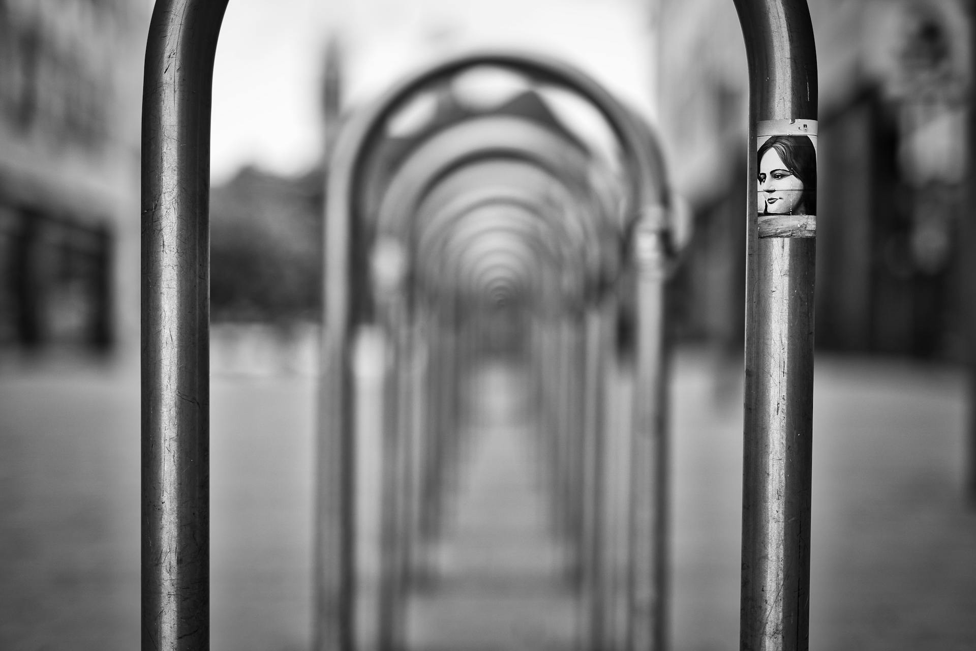 Black and white photo of a steel bike rack with a sticker in Magdeburg, Germany.