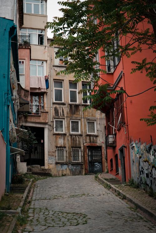 Free Explore the rustic charm of a narrow European alleyway with colorful buildings and stone pavement. Stock Photo