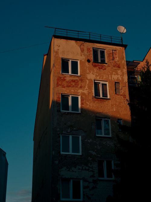 Free A photo of an old residential building with chipping paint in Bratislava during sunset. Stock Photo