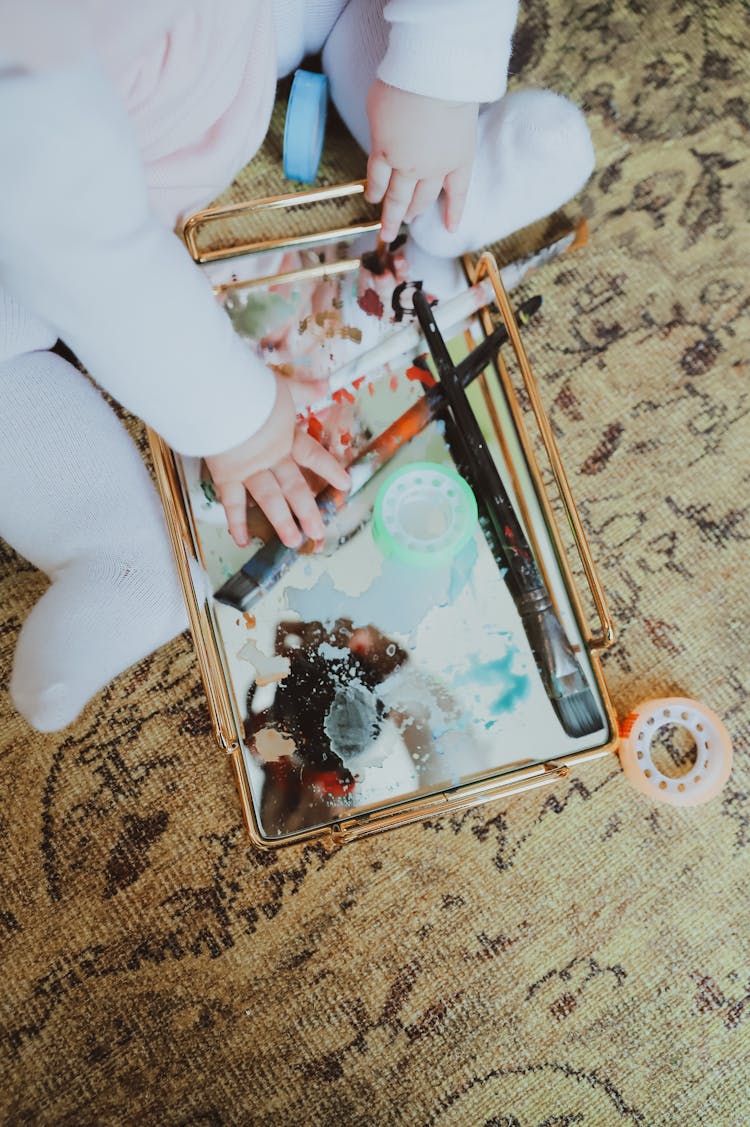 A Baby With Paintbrushes 