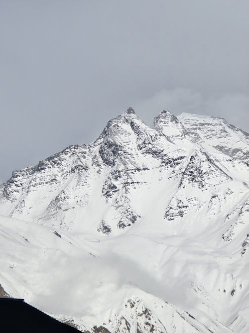 A snow covered mountain with a large snow covered peak