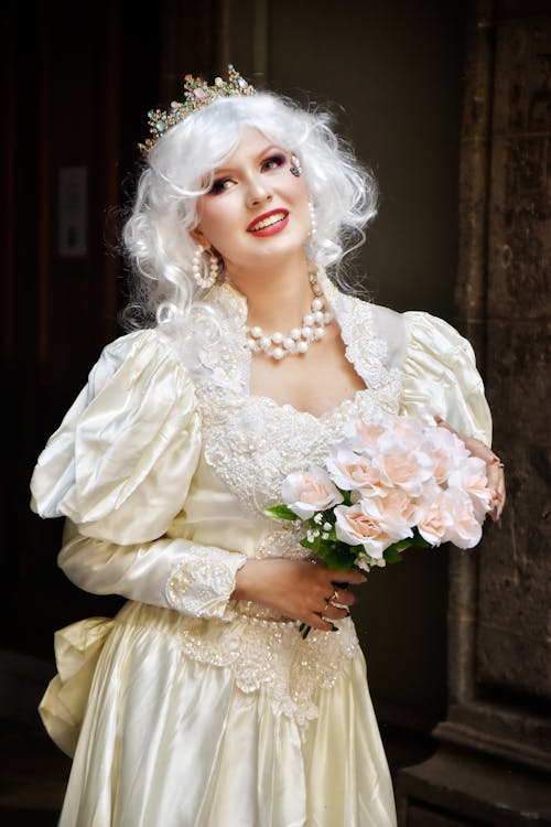 A woman in a white wedding dress holding a bouquet