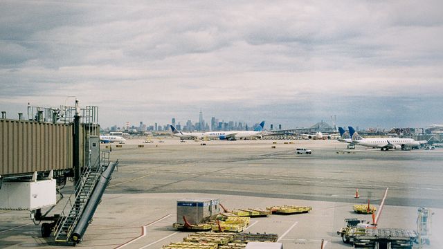 Aircraft waiting on JFK airport apron with New York City skyline in the background. — lounges at JFK Airport