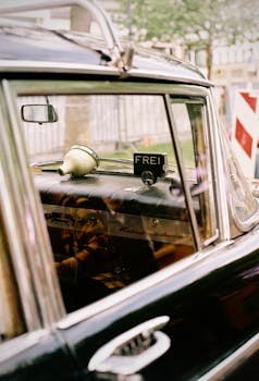 Vintage car interior with 'Frei' taxi sign in Berlin, adding a nostalgic touch.