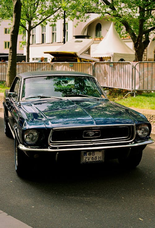 A classic blue ford mustang parked on the street