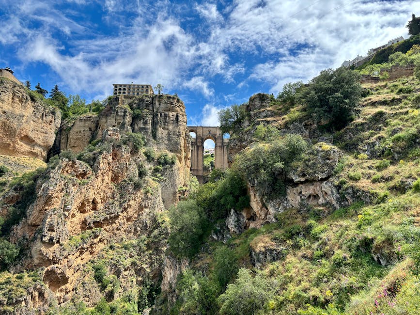 The iconic Puente Nuevo bridge spanning the gorge in Ronda, Spain, against a vibrant sky.