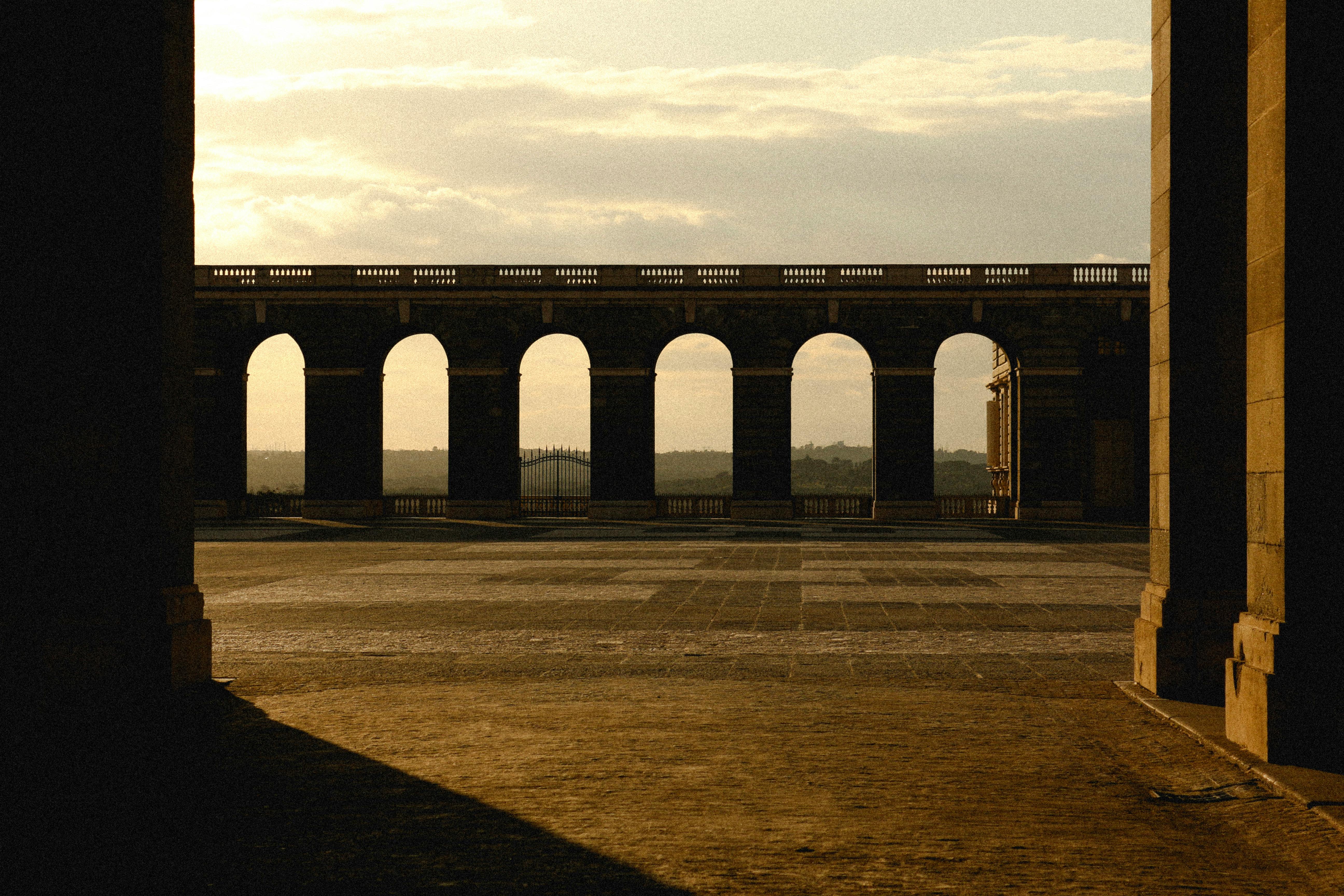 Historical arched structure in Madrid, Spain captured at sunset, showcasing architectural beauty.