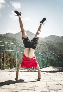 在塞浦路斯利马索尔晴朗的山区石路上，一名男子正在倒立