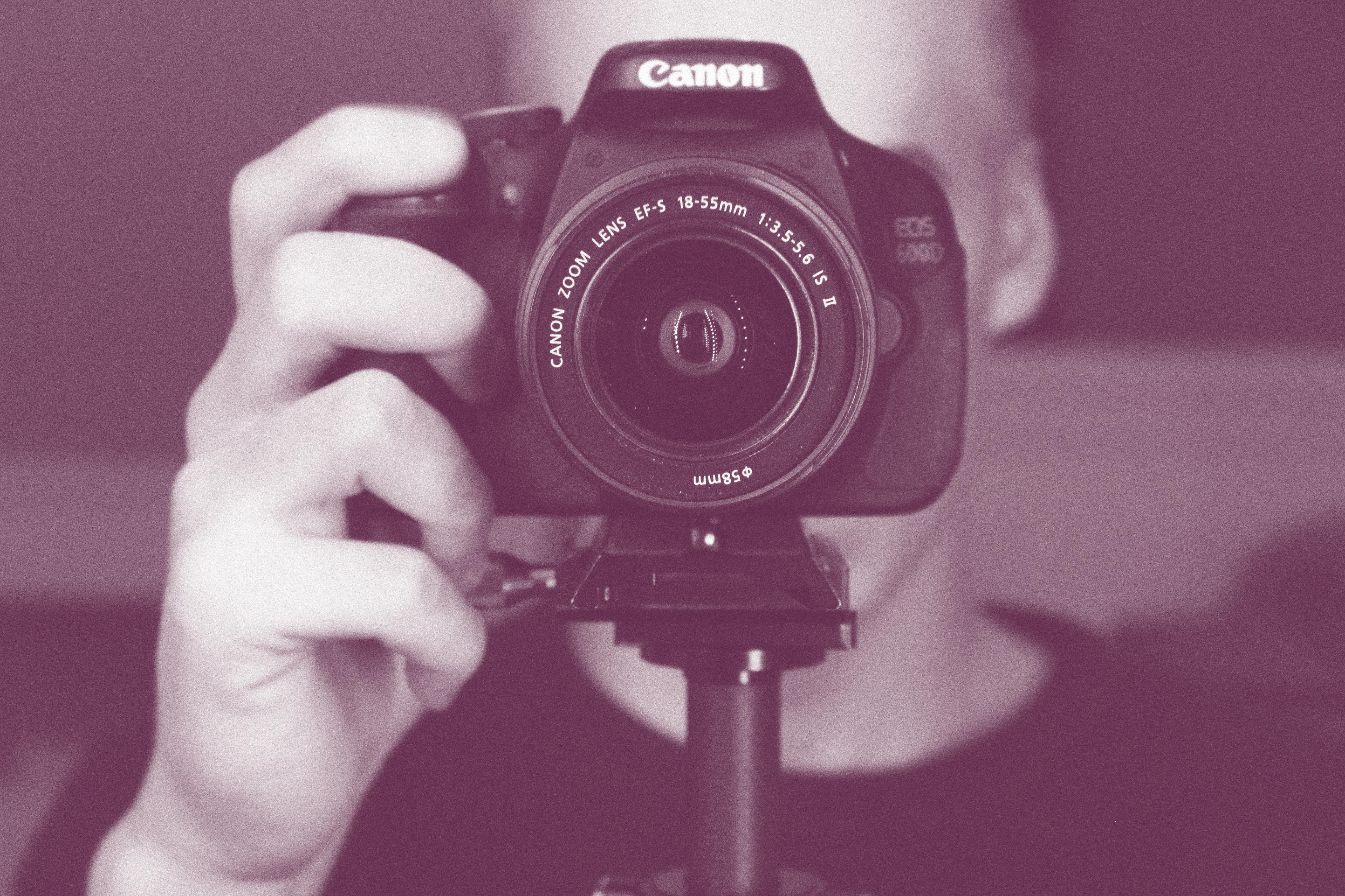 person holding black canon eos