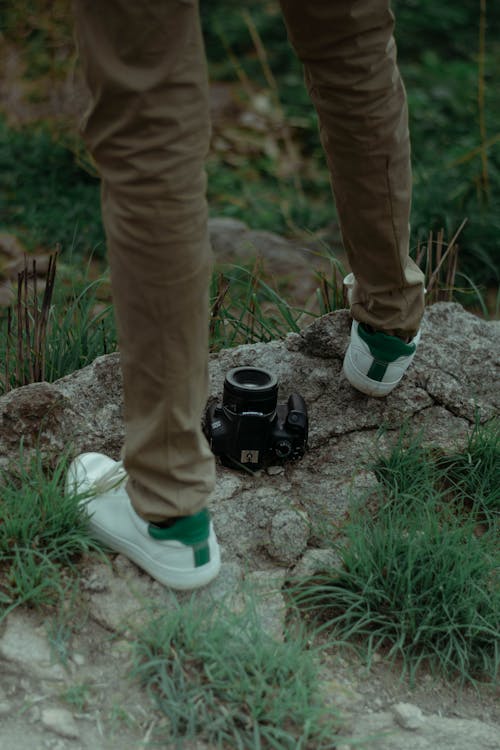 Black Camera and a Person Standing on Rocks