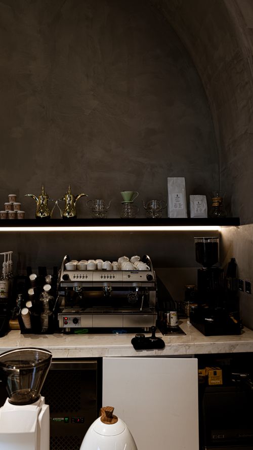 Free A chic café interior featuring a modern espresso machine with stylish décor and a warm atmosphere. Stock Photo