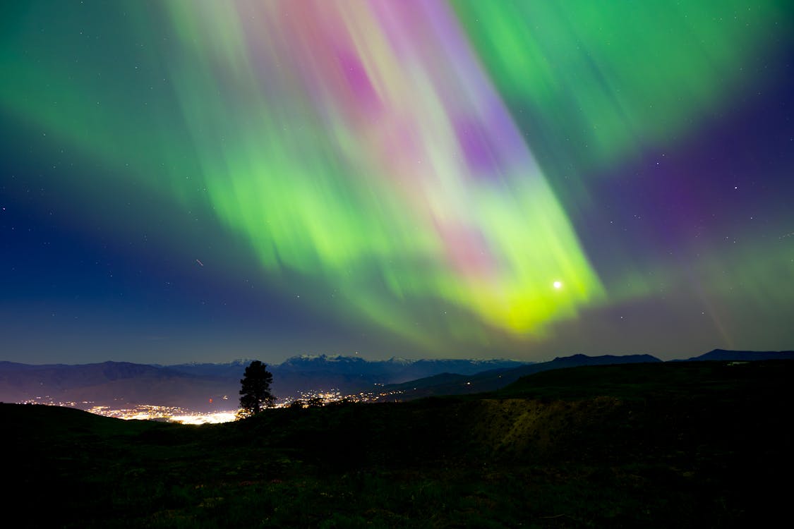 The aurora bore is seen in the sky over a mountain