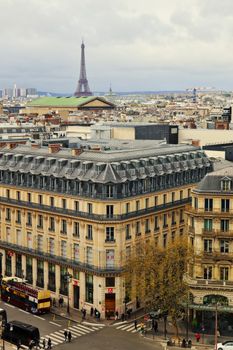 Aerial view of Paris streets and buildings with Eiffel Tower in the background.