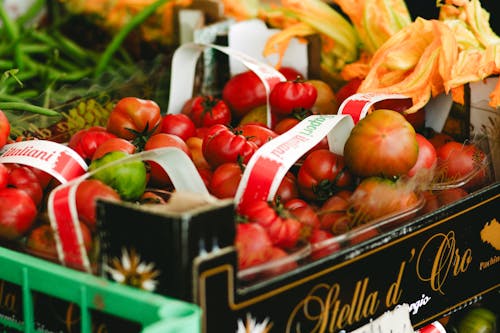 A variety of tomatoes are displayed in a crate