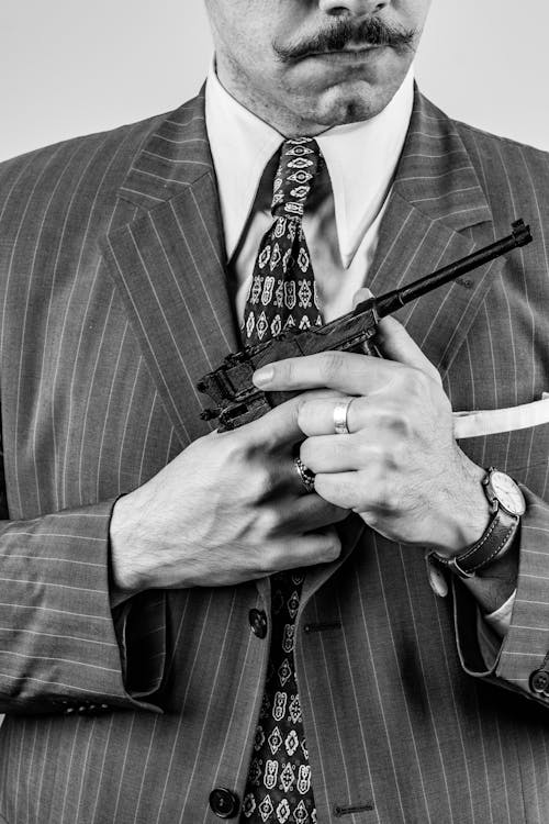 A man in a suit holding a gun