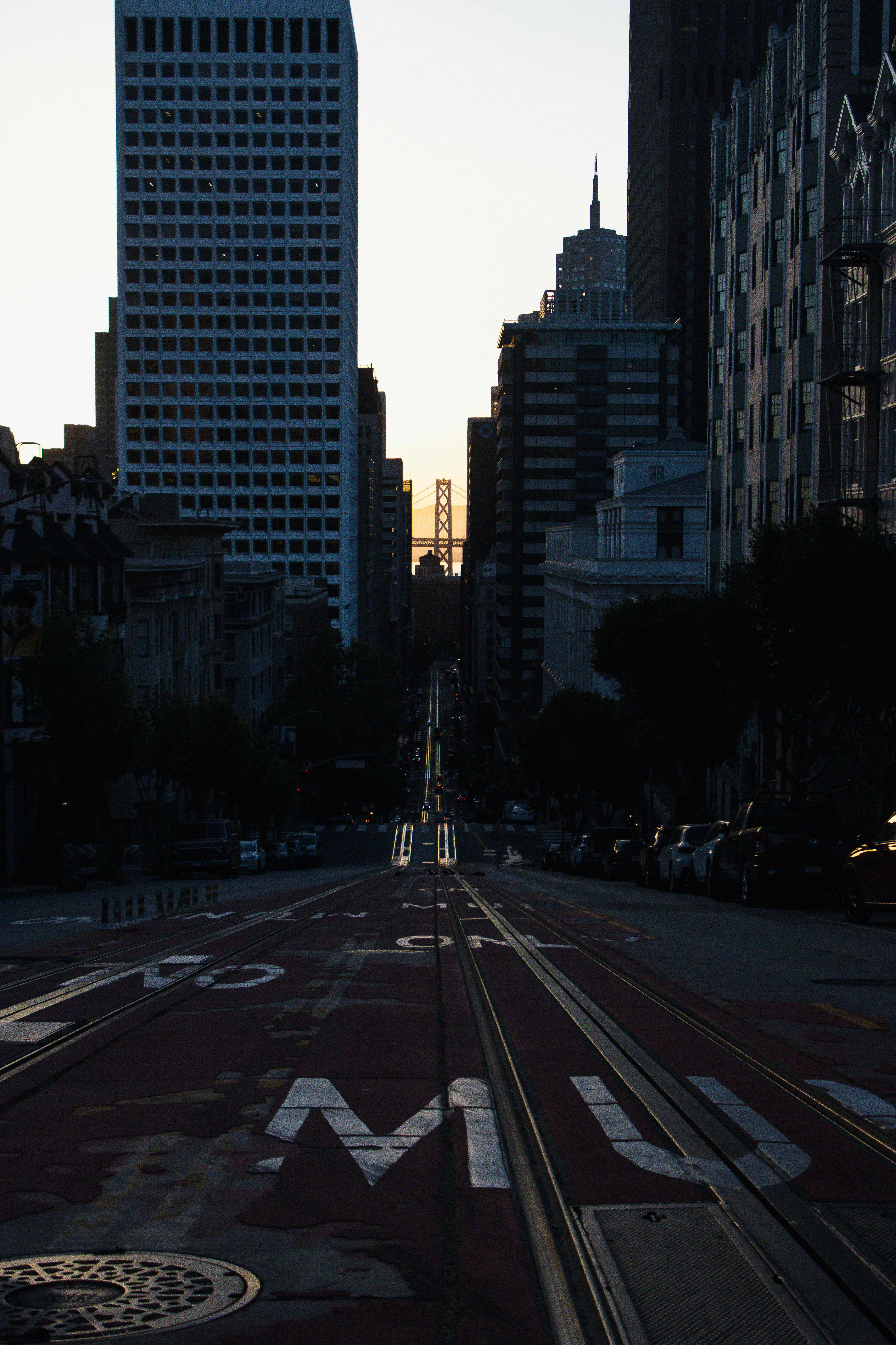 View of a city street lined with skyscrapers during twilight, capturing urban atmosphere.