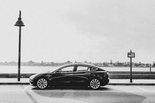 Black and white photo of a tesla car on the street