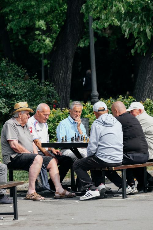 Free A group of elderly men enjoying a game of chess on a sunny day in the park. Stock Photo