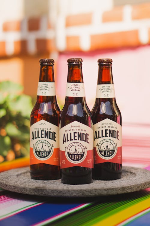Three bottles of aleine beer sit on a table