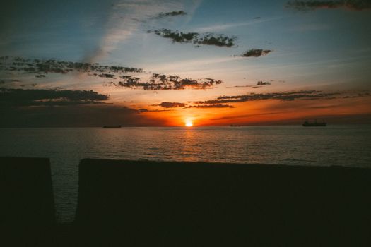 Breathtaking sunset view over the Black Sea in Batumi, Georgia, with silhouetted ships.