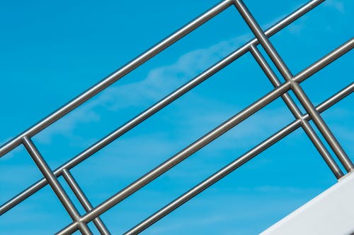 A railing with a blue sky in the background