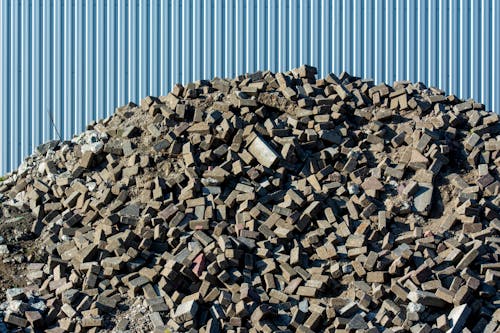 A pile of rubble next to a blue building