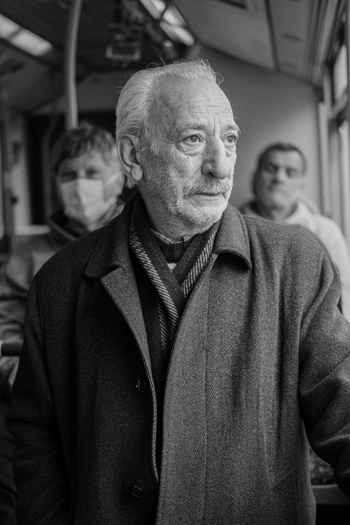 Free Black and white portrait of a senior man on a bus, showcasing his thoughtful expression. Stock Photo