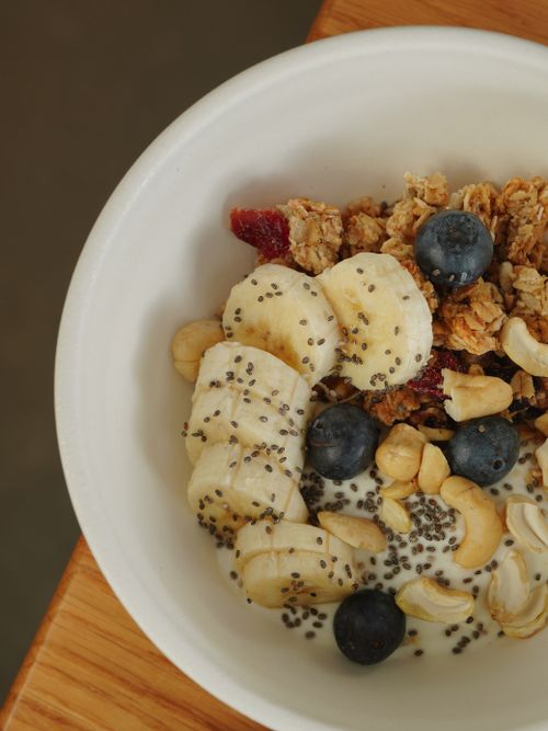 Free A nutritious breakfast bowl featuring bananas, blueberries, granola, and cashews topped with chia seeds. Stock Photo