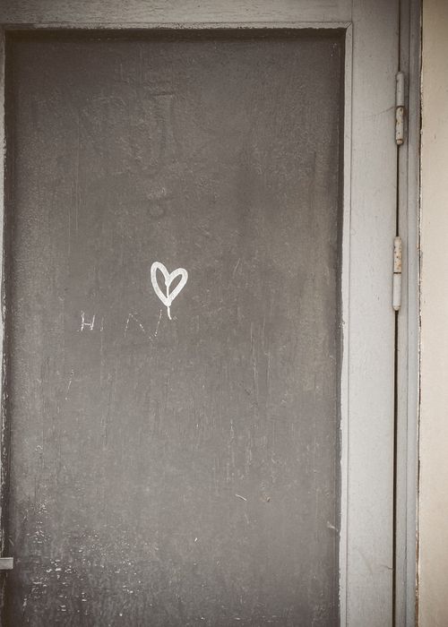 Free Close-up of a weathered door with a small white heart graffiti, exuding a vintage vibe. Stock Photo