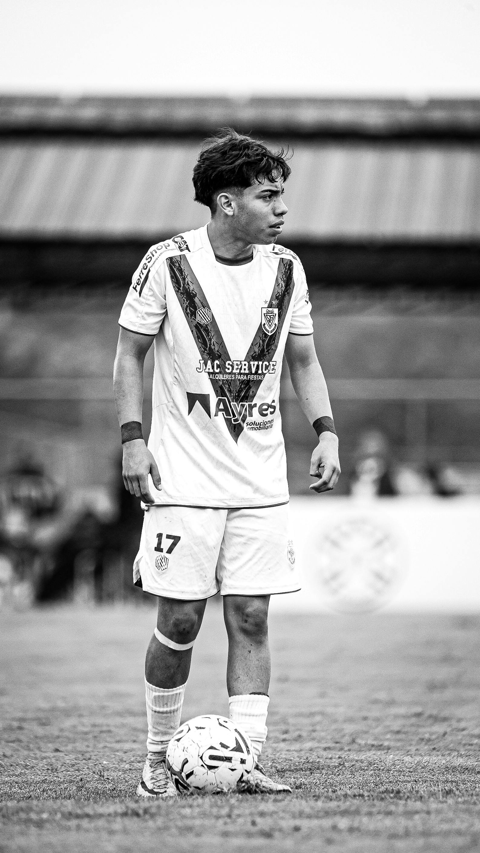 Black and white photo of a soccer player in action during a match.