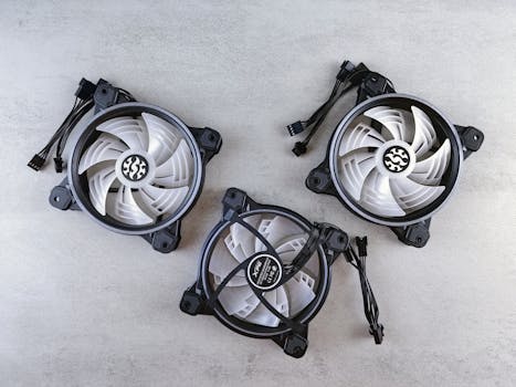 Flat lay of three computer cooling fans with cables on a light gray background for tech and electronics themes.