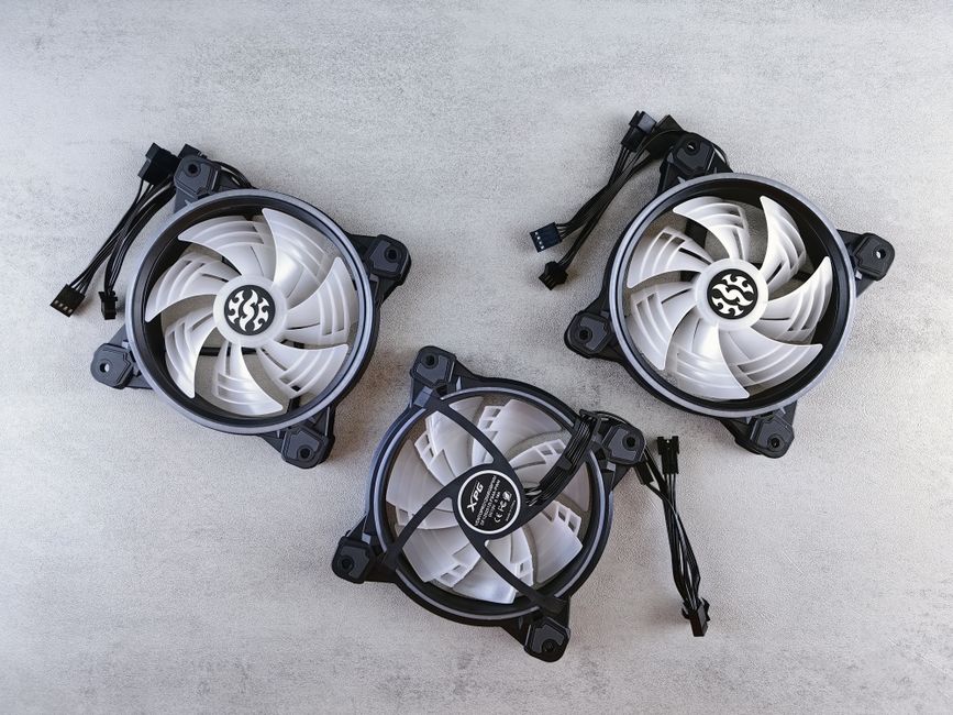 Flat lay of three computer cooling fans with cables on a light gray background for tech and electronics themes. Flat lay of three computer cooling fans with cables on a light gray background for tech and electronics themes.