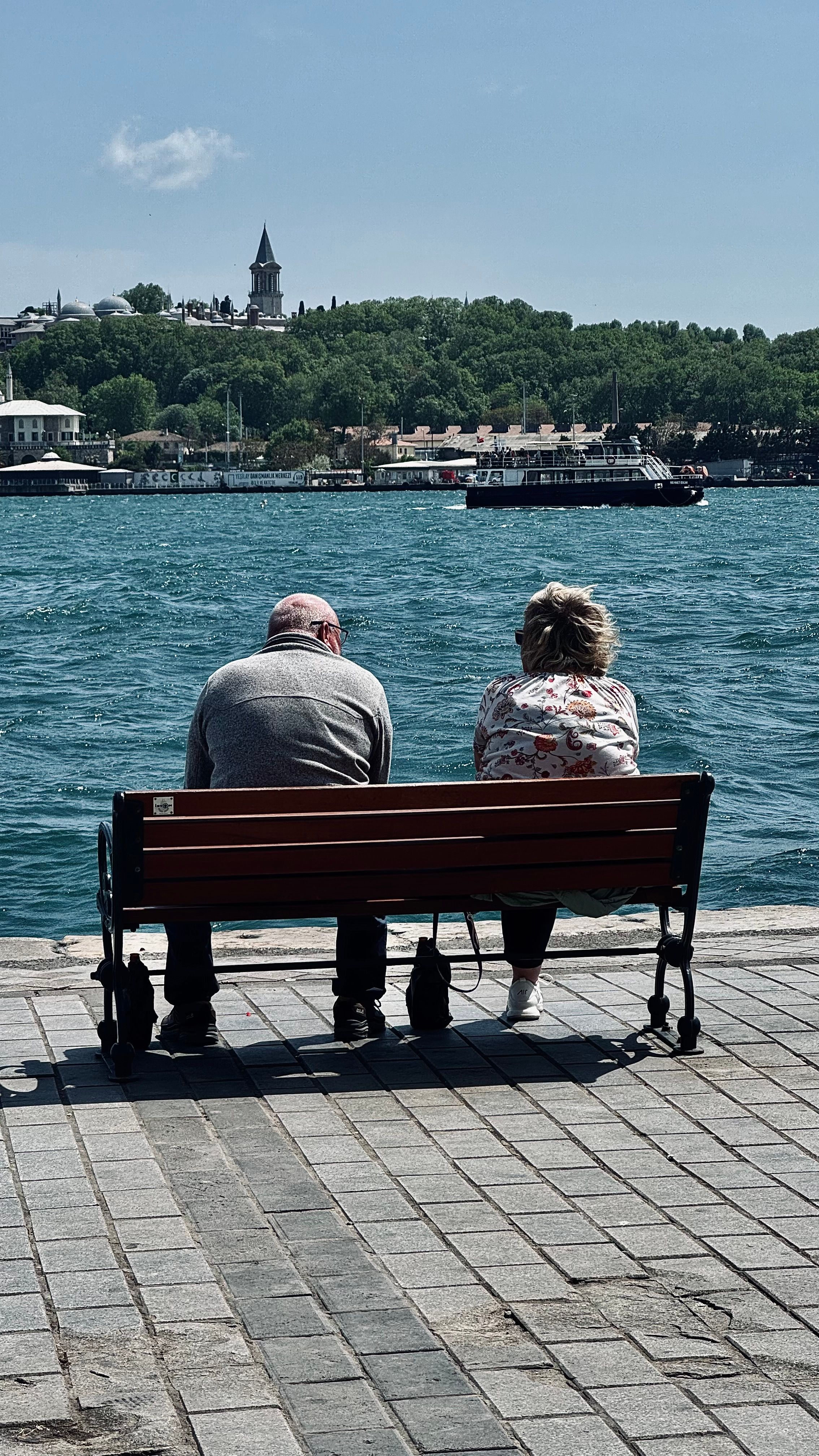 Back View of a Man and Woman Sitting on a Bench Facing the Bosphorus ...