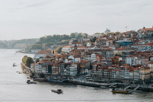 Explore a picturesque view of Porto's historic waterfront with colorful buildings and serene riverscape.