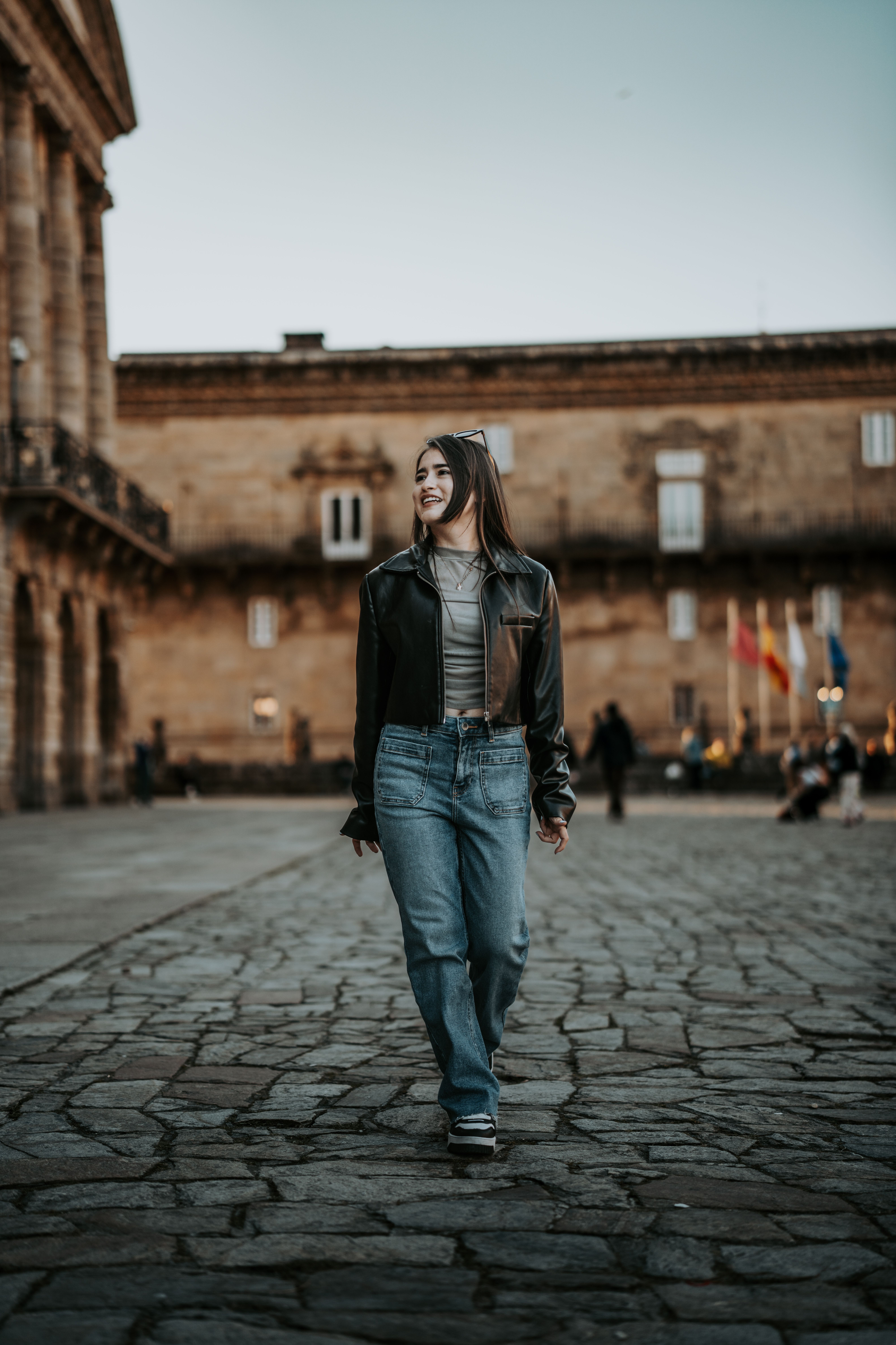 Woman Walking Down a Cobblestone Street · Free Stock Photo