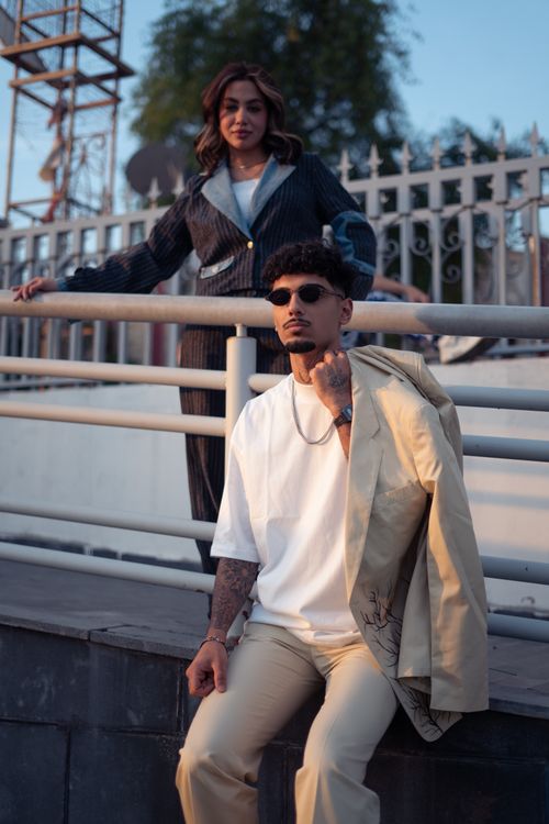 Free Well-dressed couple poses elegantly on a bridge in Baghdad during sunset. Stock Photo