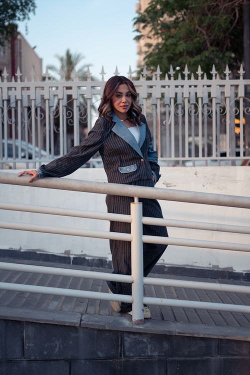 Free Stylish young woman in pinstripe suit posing by a railing in Baghdad, Iraq. Stock Photo