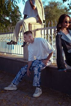 Fashionable young adults posing in stylish attire on a Baghdad street during daytime.