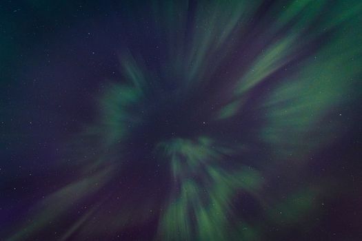 A captivating display of the aurora borealis with vibrant greens against a star-filled night sky, showcasing celestial wonder.