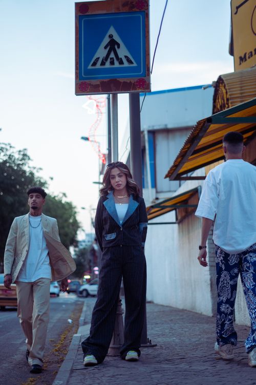Free Fashionable group wearing stylish outfits strolling on a Baghdad city sidewalk during the day. Stock Photo