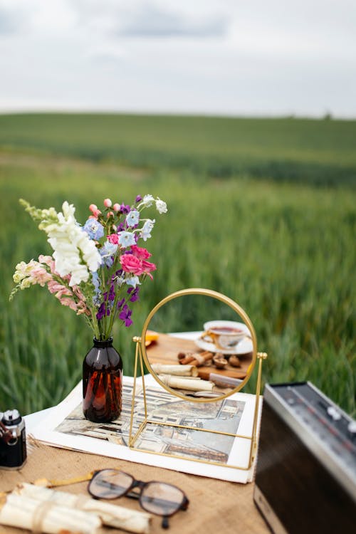 Flowers and Mirror on Table on Field