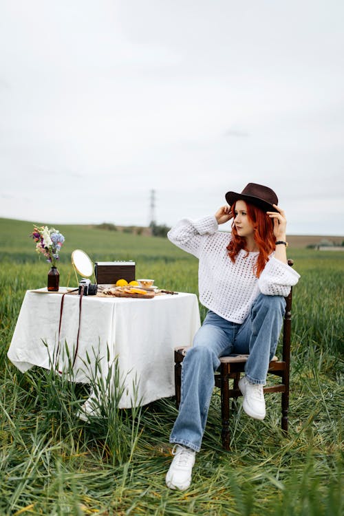 A woman sitting on a chair in a field