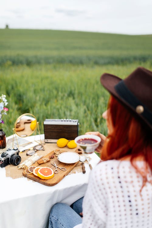 A woman sitting on a picnic table in a field